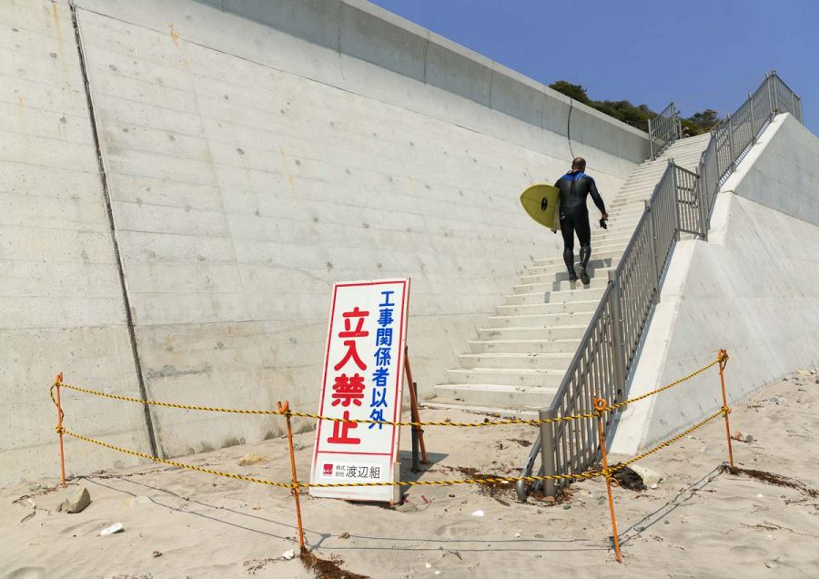 A authorized entry prohibited sign in front of a japanese surfer in the contaminated area after the daiichi nuclear power plant irradiation, Fukushima prefecture, Tairatoyoma beach, Japan